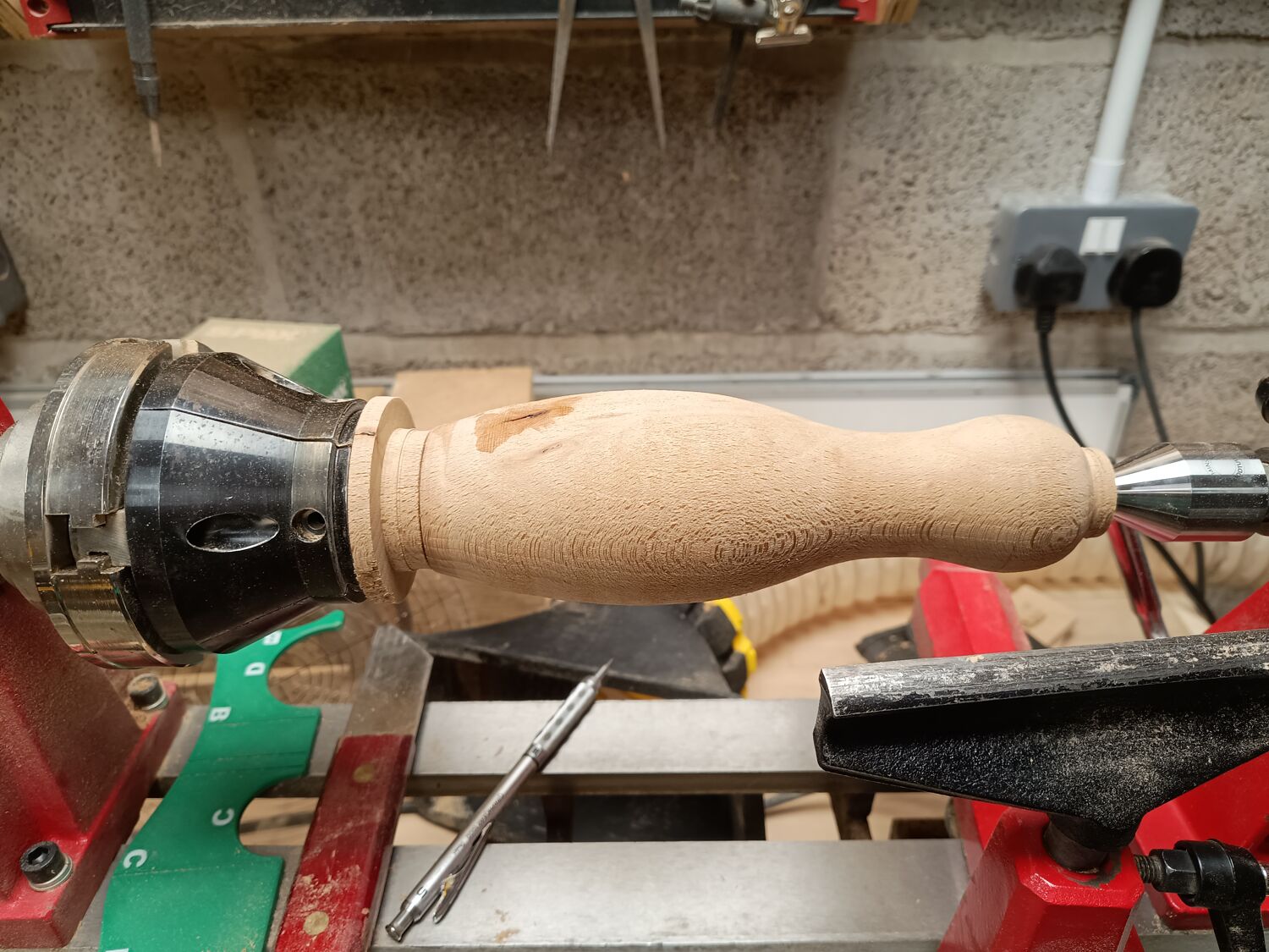 Artisan shaping wood on lathe under workshop lighting